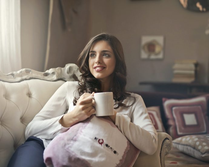 woman holding mug sitting on sofa
