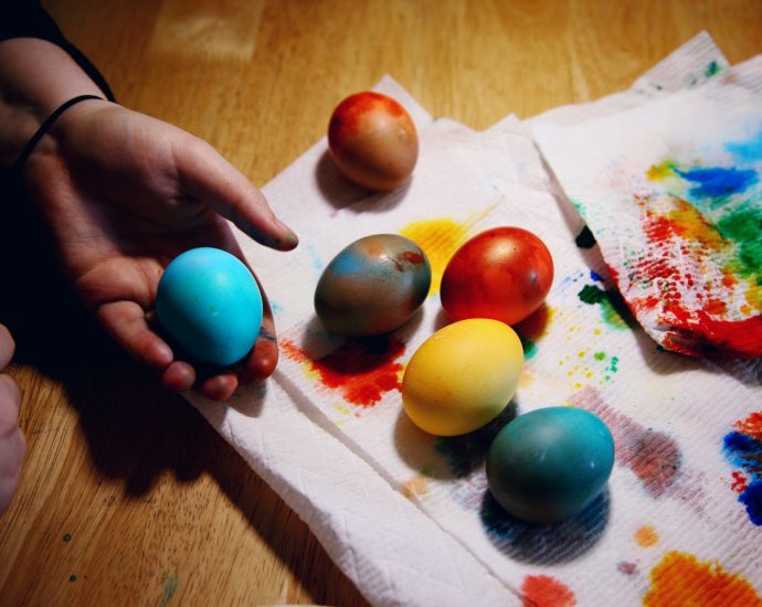 person holding red yellow and blue egg