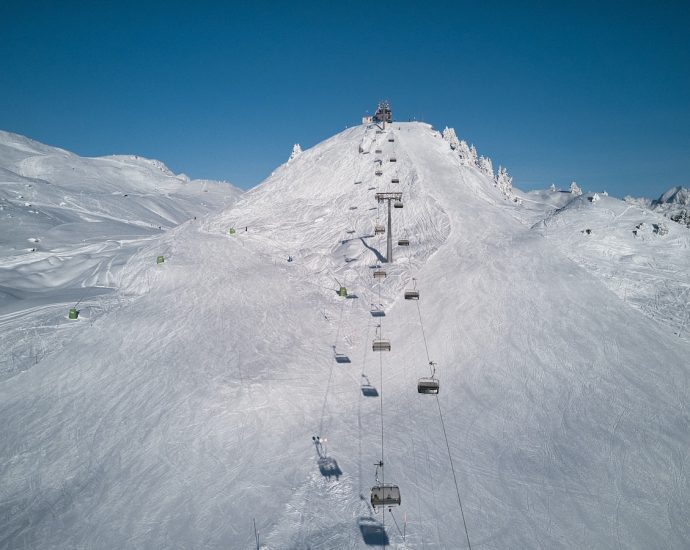 a ski lift going up the side of a snow covered mountain