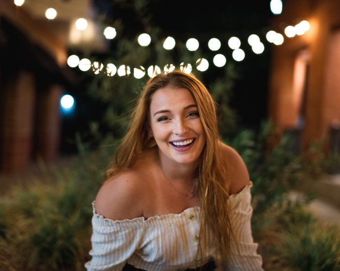 woman in white off shoulder dress smiling