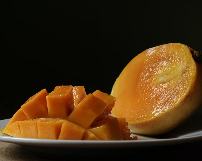 sliced orange fruit on black ceramic bowl