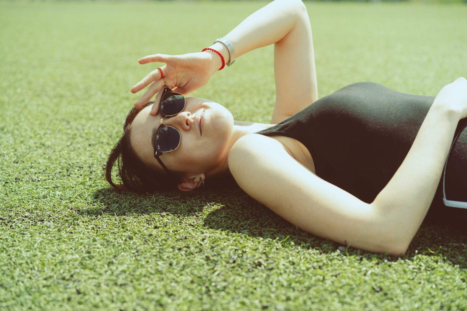 a woman laying on the ground wearing sunglasses