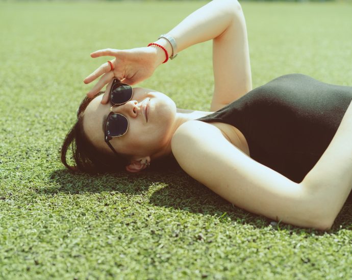 a woman laying on the ground wearing sunglasses