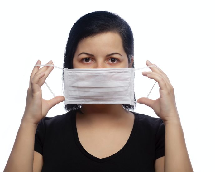 woman in black tank top covering her face with white paper