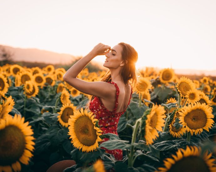 woman standing surrounding by sunflowers