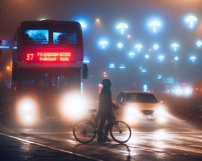 man in black jacket riding bicycle on road during night time