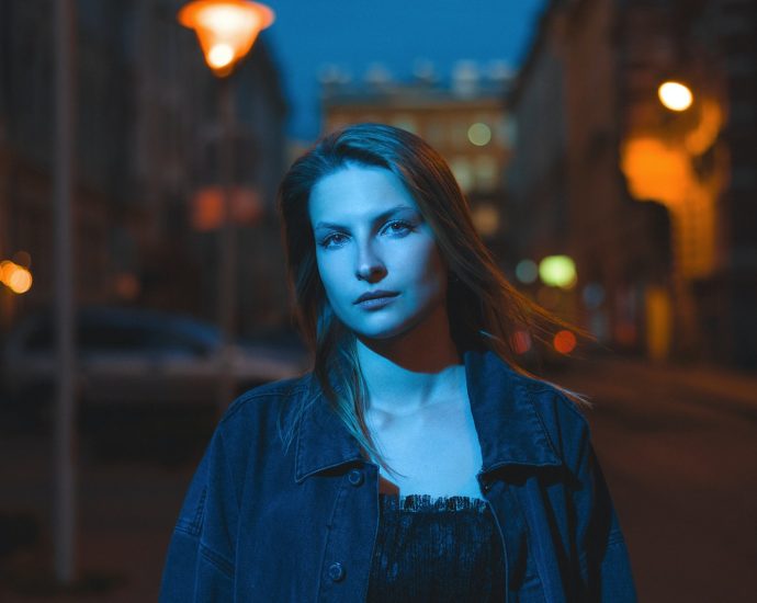 a woman standing on a city street at night