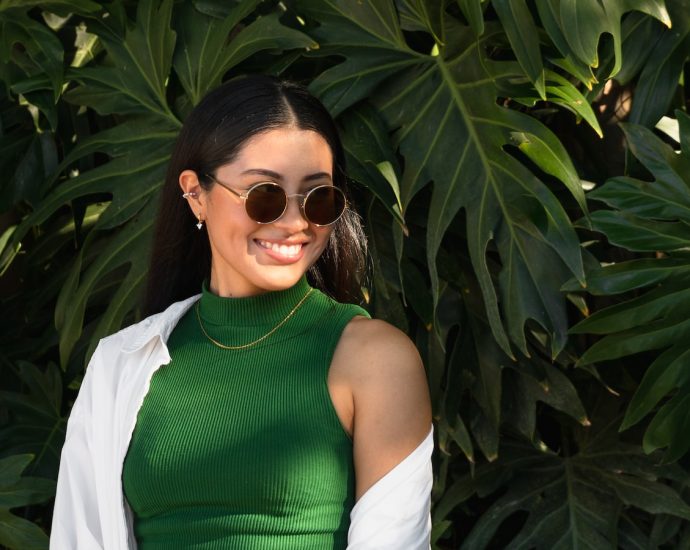 a woman wearing sunglasses and a green dress