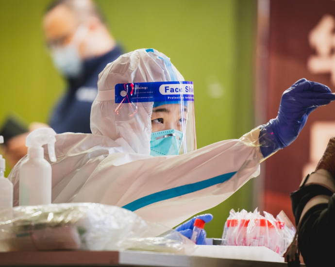 a person wearing a protective suit and holding a toothbrush