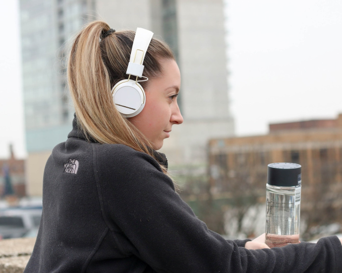 woman wearing black The North Face jacket and white headphones
