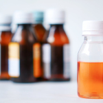 Orange and White Bottles on White Table