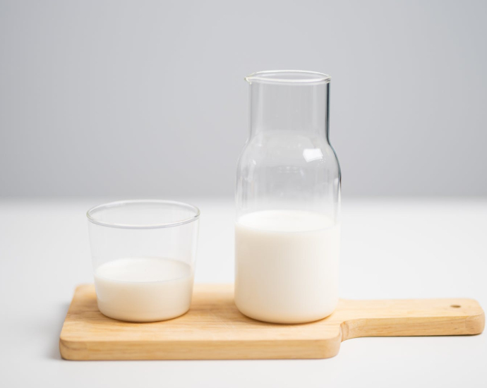 Milk in Pitcher and Glass Placed on Wooden Chopping Board