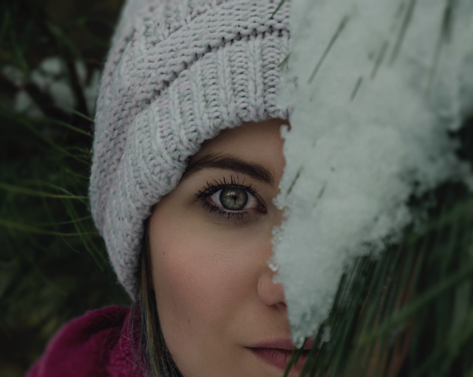 woman's face covered by green plant