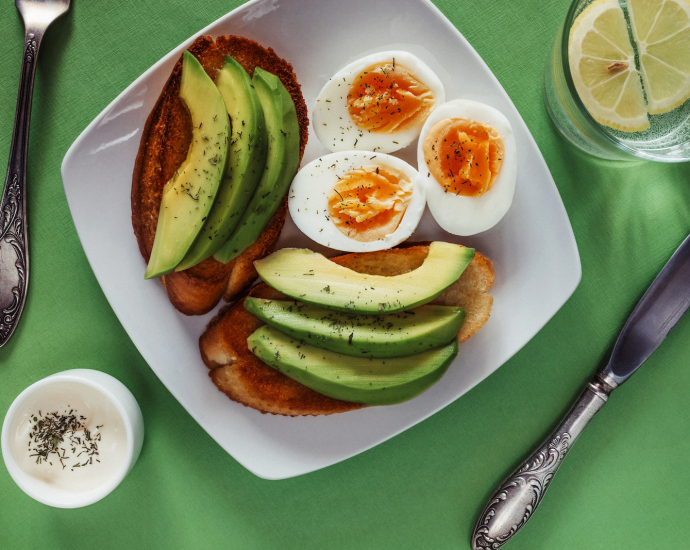 a white plate topped with eggs and avocado