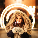 woman wearing coat and holding fireworks