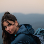 a woman in a blue jacket looking at the camera