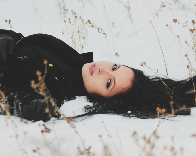 woman laying on snowy ground
