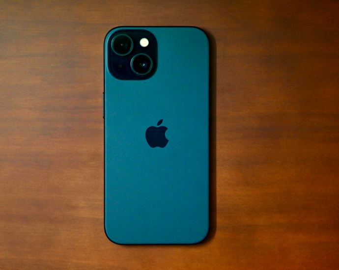 a blue iphone sitting on top of a wooden table