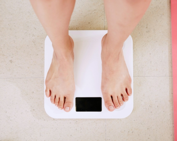 person standing on white digital bathroom scale