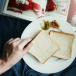 Person Touching the Bread on Plate