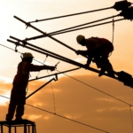Silhouette of Two Electricians Working