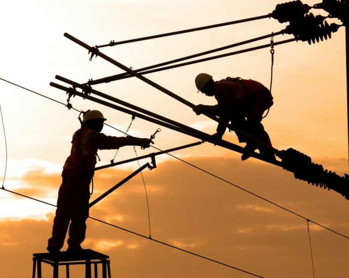 Silhouette of Two Electricians Working