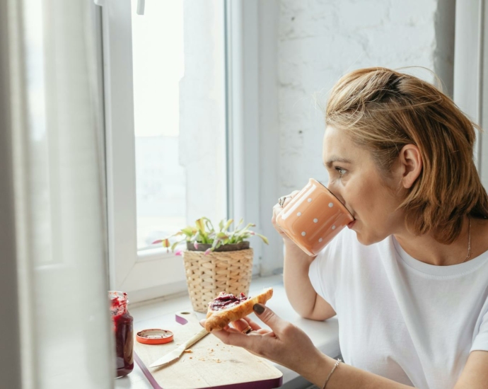 Woman Drinking Coffee on a Peach Colored Mug