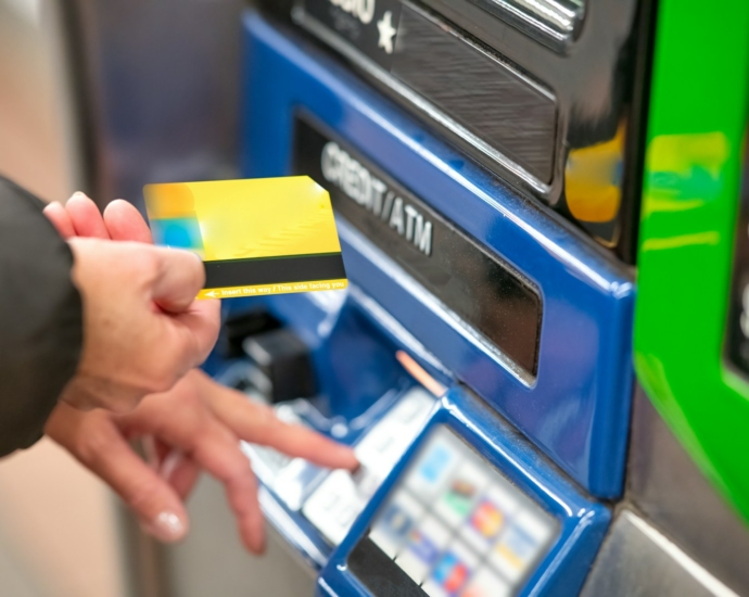 a person using a credit card to pay for a machine
