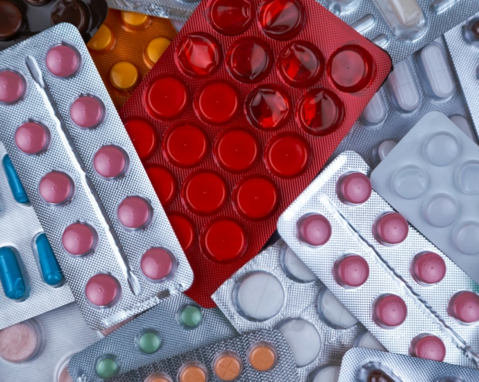 pile of blister packs of colorful medicine tablets