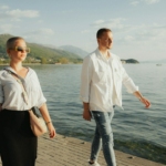 a man and a woman walking along a pier