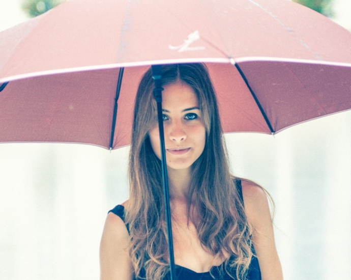 woman holding red umbrella in closeup photography