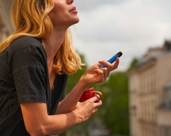 a woman holding a cup and a cell phone