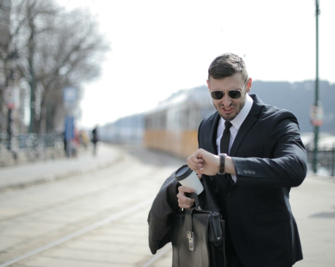 Man in Black Suit Jacket Holding Black Leather Bag