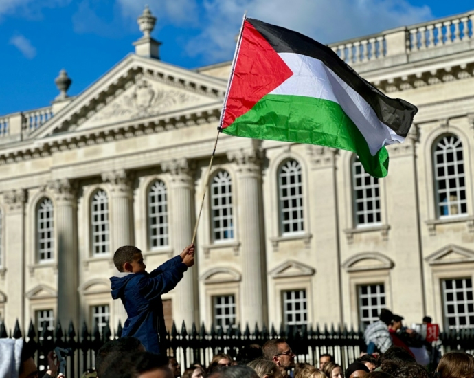 a young boy holding a flag in front of a building