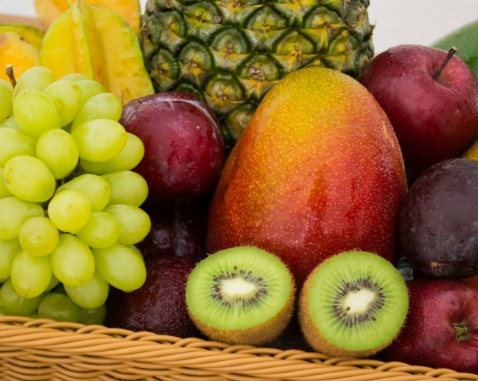 red apple fruit beside green apple and yellow fruit on brown woven basket