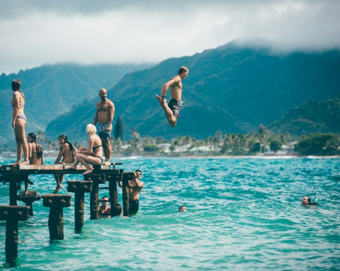 man diving from dock with people