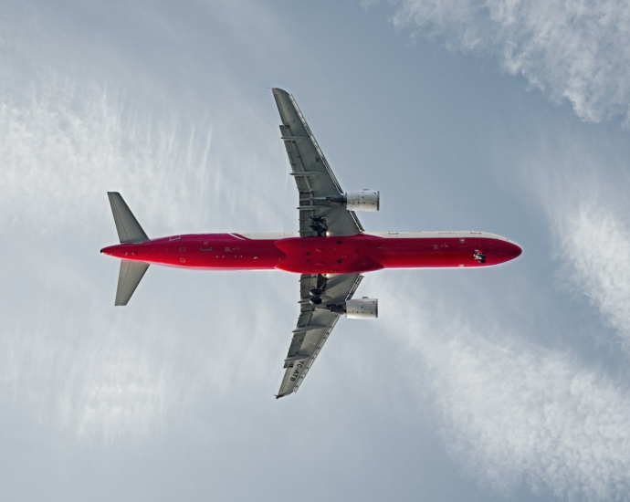 red and white passenger airplane on the sky during daytime