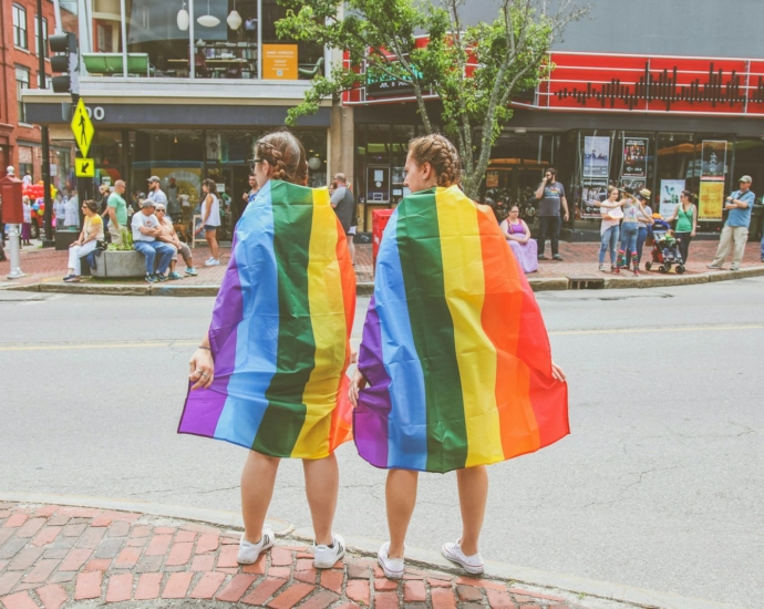 two women standing near curb during daytime