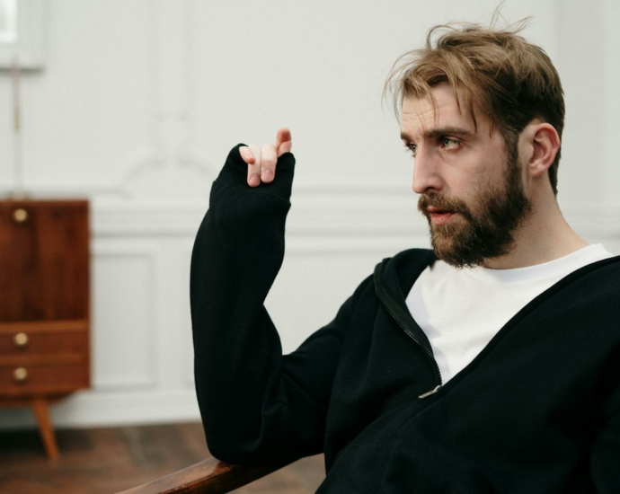 Man in Black Sweater Sitting on Brown Wooden Chair