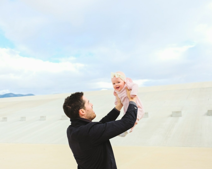 man carrying baby during daytime