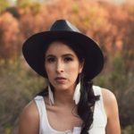 A woman wearing a black hat and a white shirt