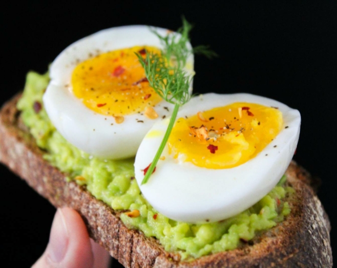 Sliced Egg on Top of Green Salad With Bread