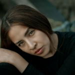 A woman is posing for a picture in a black shirt