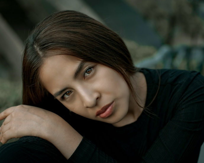 A woman is posing for a picture in a black shirt