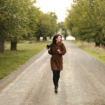 A woman is running down a dirt road