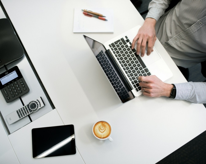 person using laptop on white wooden table