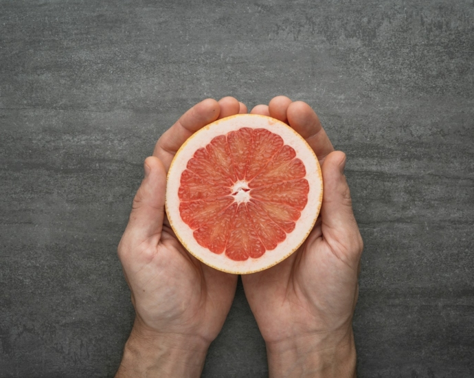 person holding orange citrus fruit