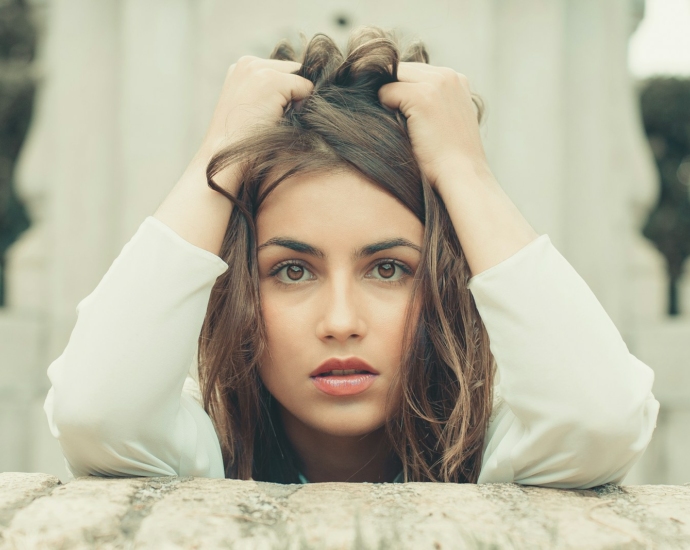 woman in white long sleeve shirt lying on bed