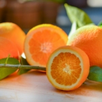 a group of oranges sitting on top of a wooden table