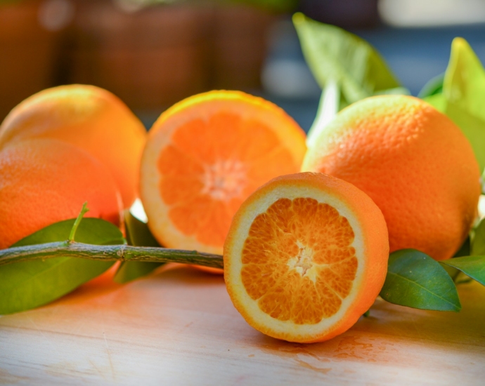 a group of oranges sitting on top of a wooden table